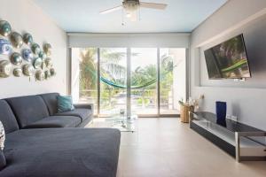 a living room with a couch and a tv at Escape to a peaceful side of the Riviera Maya in Lafitte