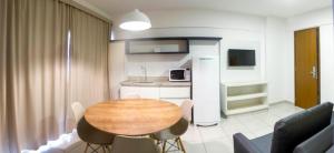 a living room with a table and a kitchen at Evian Thermas Residence in Caldas Novas
