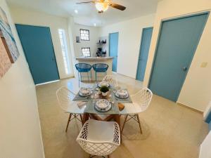 a dining room with a table and chairs and blue doors at Novaga Pto Morelos in Puerto Morelos
