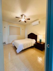 a bedroom with a bed and a ceiling fan at Novaga Pto Morelos in Puerto Morelos