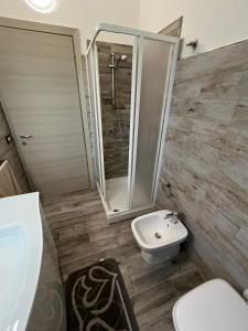 a bathroom with a shower and a toilet and a sink at Casa Alma in Porto Pino
