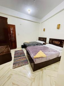 una camera con 2 letti e un tappeto di Adrar nshal ادرار نشال a Siwa