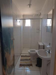 ein Badezimmer mit Toilette und Waschbecken in der Unterkunft Praia de Massaguaçu in Caraguatatuba