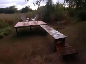 a wooden platform with two chairs sitting on top of it at Los furgones de Areco in San Antonio de Areco