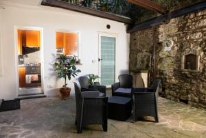 a patio with chairs and a table and a stone wall at ST. JAMES HOME CITTÀ ALTA in Bergamo