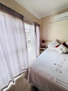 a bedroom with a white bed and a window at Oteng Lifestyle BnB in Rustenburg +72 photos