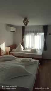 a hotel room with two beds and a window at Casa Livada Bunicii in Tîrgu Ocna +87 photos