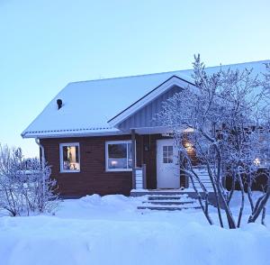 a house with snow on the ground in front of it at Villa with hot tub and sauna in Umeå