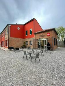a building with tables and chairs in front of it at Ca Rossa in Bondeno