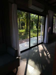 春蓬Onlyfan hostel的一间设有滑动玻璃门的客房,可通往庭院