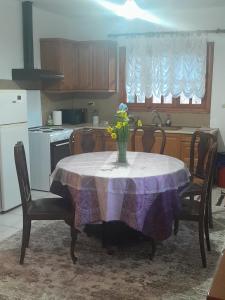 a kitchen with a table with a vase of flowers on it at Helmos Mountain View in Kértezi