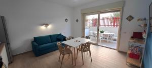 a living room with a blue couch and a table at Appartamento Galatea mare in SantʼAlessio Siculo