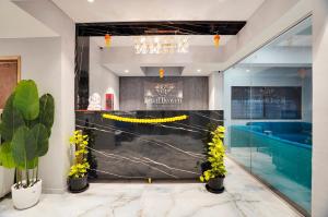 a lobby with a black wall with yellow flowers at Hotel Regal Heaven in Pune