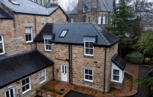 a large brick house with a black roof at Luxury two bed inc hot-tub in Harrogate