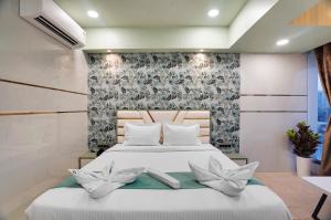 a bedroom with a white bed with flowers on it at Hotel Regal Heaven in Pune