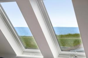 a room with two windows with a view of the ocean at Havudsigt Ferielejlighed in Dannemare +30 photos