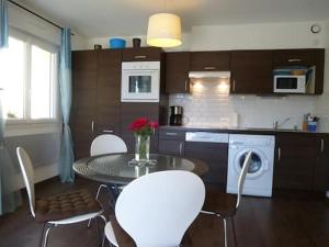 a kitchen with a table and chairs and a kitchen with a sink at AB Bel appartement 1 à 4 pers face vallée 3 étoiles WIFI in Le Tholy