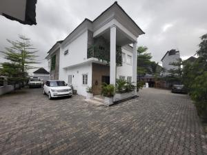 a white house with a car parked in a driveway at Taverna Lounge & Boutique Hotel in Port Harcourt