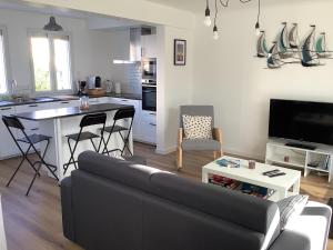 un salon avec un canapé et une cuisine avec une table dans l'établissement Gite Ty ar vor classé 3 étoiles, à Paimpol