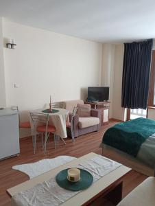 a living room with a bed and a couch and a table at Sunny studio in Pamporovo in Pamporovo