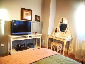 a bedroom with a television and a mirror at La vida sin reloj a un paseo de la playa in Ancillo