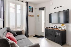 a living room with a couch and a flat screen tv at Escale à Clisson - L'atelier in Clisson +24 photos