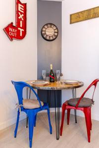 a table and chairs with wine glasses and a clock at Escale à Clisson - L'atelier in Clisson