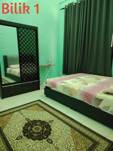 a bedroom with a bed and a mirror and a rug at Afwan homestay klebang melaka in Melaka +10 photos