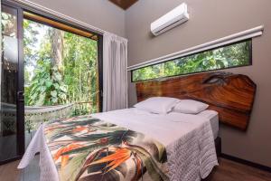 a bedroom with a bed and a large window at Río Sarapiquí Lodge in Sarapiquí