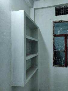 a white shelf in a room with a window at Shivay Aparts in Naini