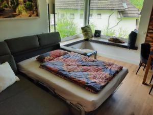 een bed in een woonkamer met een bank en een raam bij Ferienwohnung Sonnenseite in Cochem