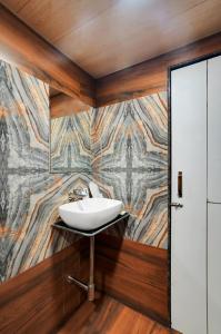 a bathroom with a sink and a mosaic wall at Hotel Regal Heaven in Pune +23 photos