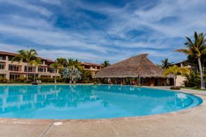 a large blue swimming pool in front of a resort at El Tigre, Isla Palmares with Balcony & Shared Pool in Nuevo Vallarta  +40 photos