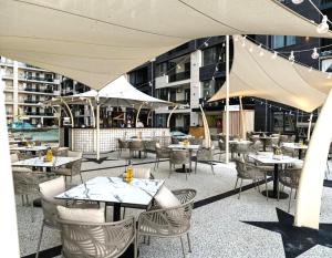 a restaurant with tables and chairs and a building at Mamaia Nord Resort Premium in Mamaia Sat/Năvodari