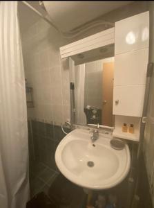 ein Badezimmer mit einem weißen Waschbecken und einem Spiegel in der Unterkunft Spacious Modern Two-Bedroon Suite in Elit 1 Complex in Sonnenstrand