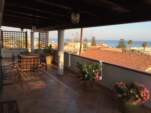 balcone con tavoli, sedie e vista sull'oceano di Casa vacanze da Giovanni a Marina di Ragusa