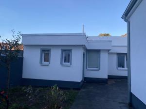 ein weißes Haus mit einem Zaun in der Unterkunft Minos Bungalow in Oberhausen