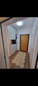 a large room with a door and a room with a rug at M&E Prishtina apartment in Prishtinë