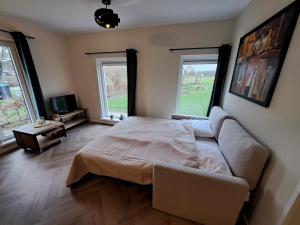 a bedroom with a bed and a couch and two windows at Erve Lindehof in Lochem +28 photos