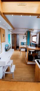- une cuisine avec des tables et des bancs blancs dans une pièce dans l'établissement Odyssée gîte sur Péniche, à Saint-Valery-sur-Somme