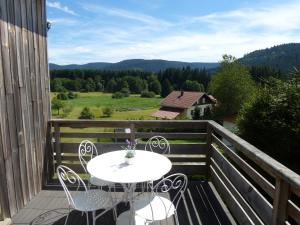 a table and chairs on a balcony with a view at AH Large apartment 1 a 7 pers 3 stars WiFi in Le Tholy