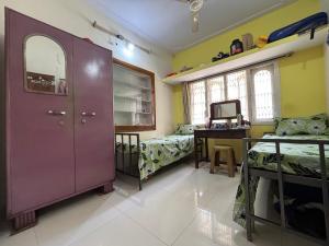 Habitación con puerta morada, escritorio y dormitorio. en Home suite, en Bangalore