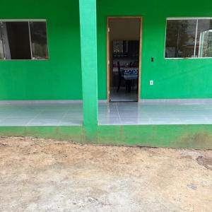 a green wall of a house with a dining room at Chalé orquídea in Santana do Riacho