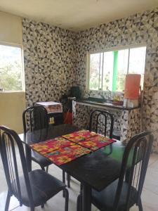 a dining room with a table and chairs in a room at Chalé orquídea in Santana do Riacho