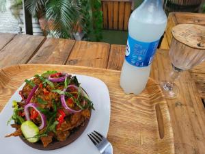 a plate of food with a salad and a bottle of milk at Taverna Lounge & Boutique Hotel in Port Harcourt