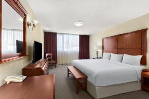 a hotel room with a large white bed and a desk at Howard Johnson by Wyndham Toluca in Toluca