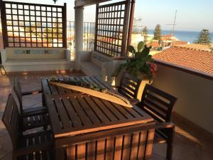 a surfboard sitting on a bench on a balcony at Casa vacanze da Giovanni in Marina di Ragusa +18 photos