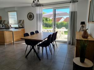 a kitchen and dining room with a table and chairs at Le chou marin, charmante maison de plain-pied proche d'Audresselles & du Cap gris nez in Audinghen