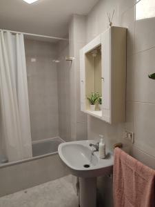 a white bathroom with a sink and a shower at Apartamento vacacional Meira in Meira