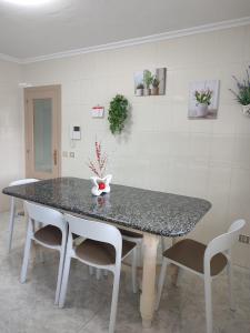 a dining room table with chairs and a counter top at Apartamento vacacional Meira in Meira +8 photos